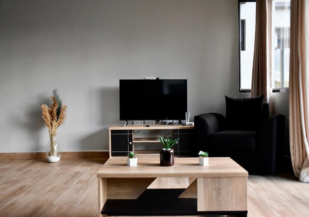 sala de estar con TV y mesa de centro en Bel appartement proche de la plage Trou Aux Biches, en Trou aux Biches