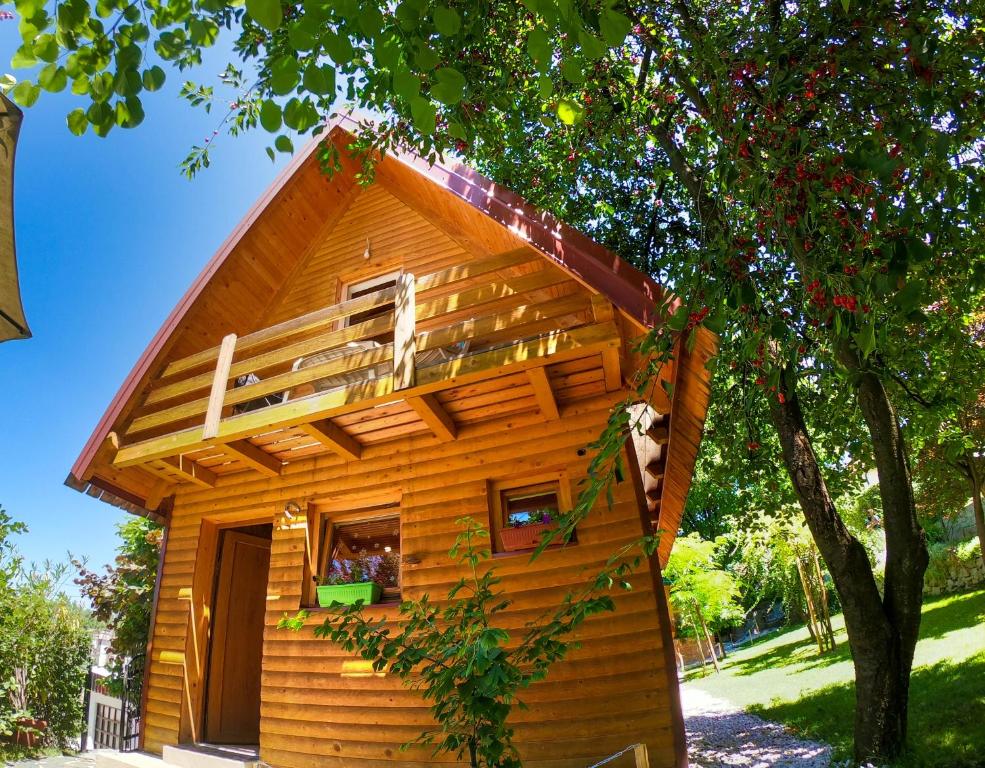 a small wooden cabin with a tree at Sarajevo Chalet in Hadžići
