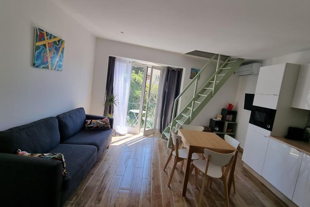 ein Wohnzimmer mit einem blauen Sofa und einem Tisch in der Unterkunft Appartement Premium in Beaulieu-sur-Mer