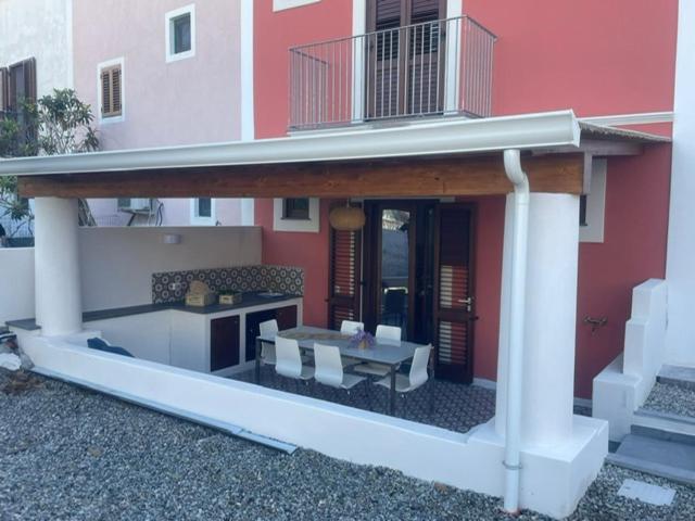 un patio di una casa con tavolo e sedie di Casa Grazia Apartments a Città di Lipari
