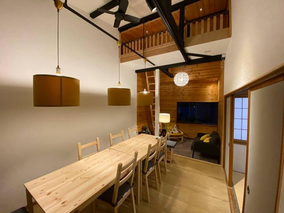 a dining room with a long wooden table and chairs at FTH Moon Light 3min to Sta. in Shimo-yoshida
