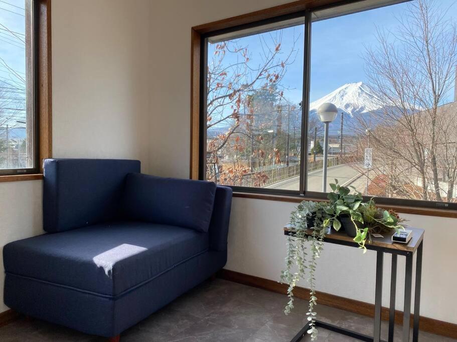 a blue couch in a room with a large window at FTH Moon Light 3min to Sta. in Shimo-yoshida