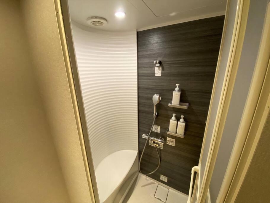 a bathroom with a shower with a black wall at FTH Moon Light 3min to Sta. in Shimo-yoshida