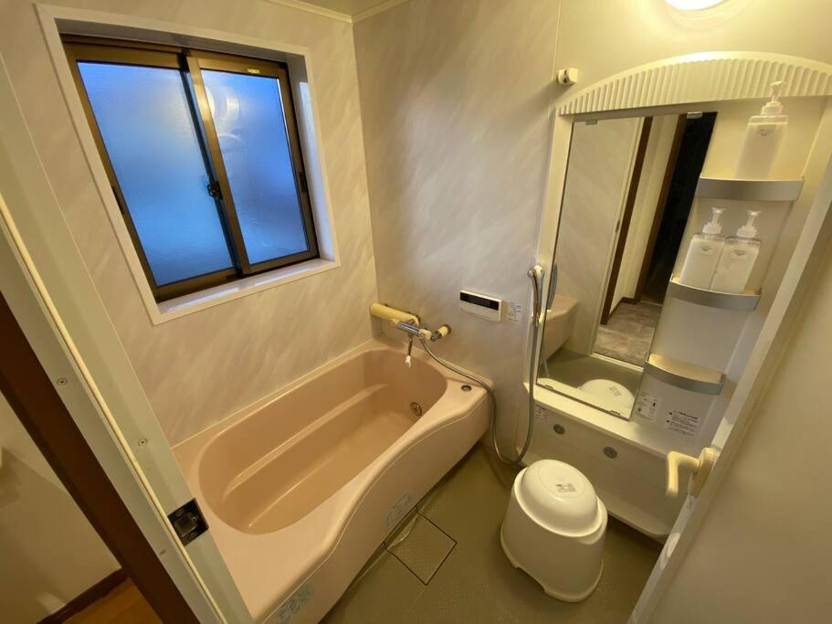 a bathroom with a tub and a toilet and a sink at FTH Moon Light 3min to Sta. in Shimo-yoshida