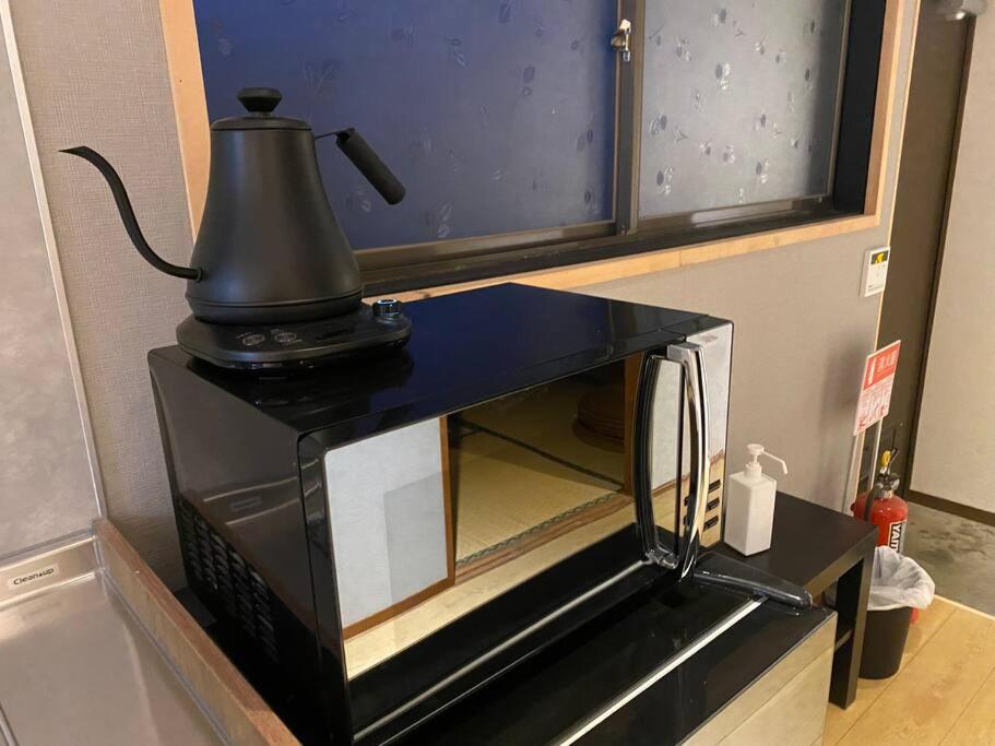 a coffee maker sitting on top of a microwave at FTH Moon Light 3min to Sta. in Shimo-yoshida