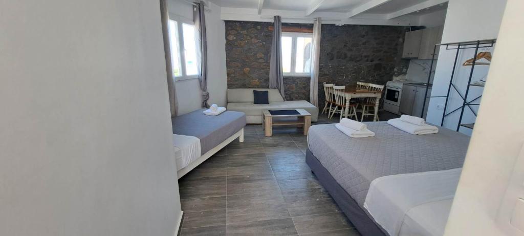 a small room with two beds and a table at Fabrica Sunset Apartments in Megali Ammos