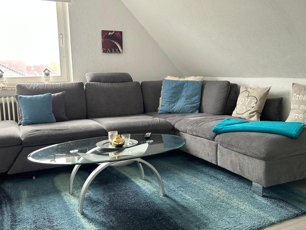 a living room with a couch and a glass table at Ferienwohnung Am Schwanenteich in Norden
