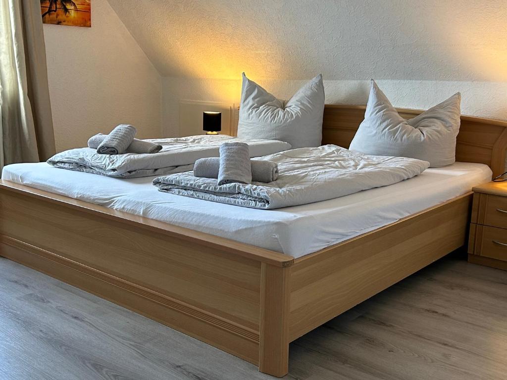 two beds with white sheets and pillows on them at Ferienwohnung Am Schwanenteich in Norden