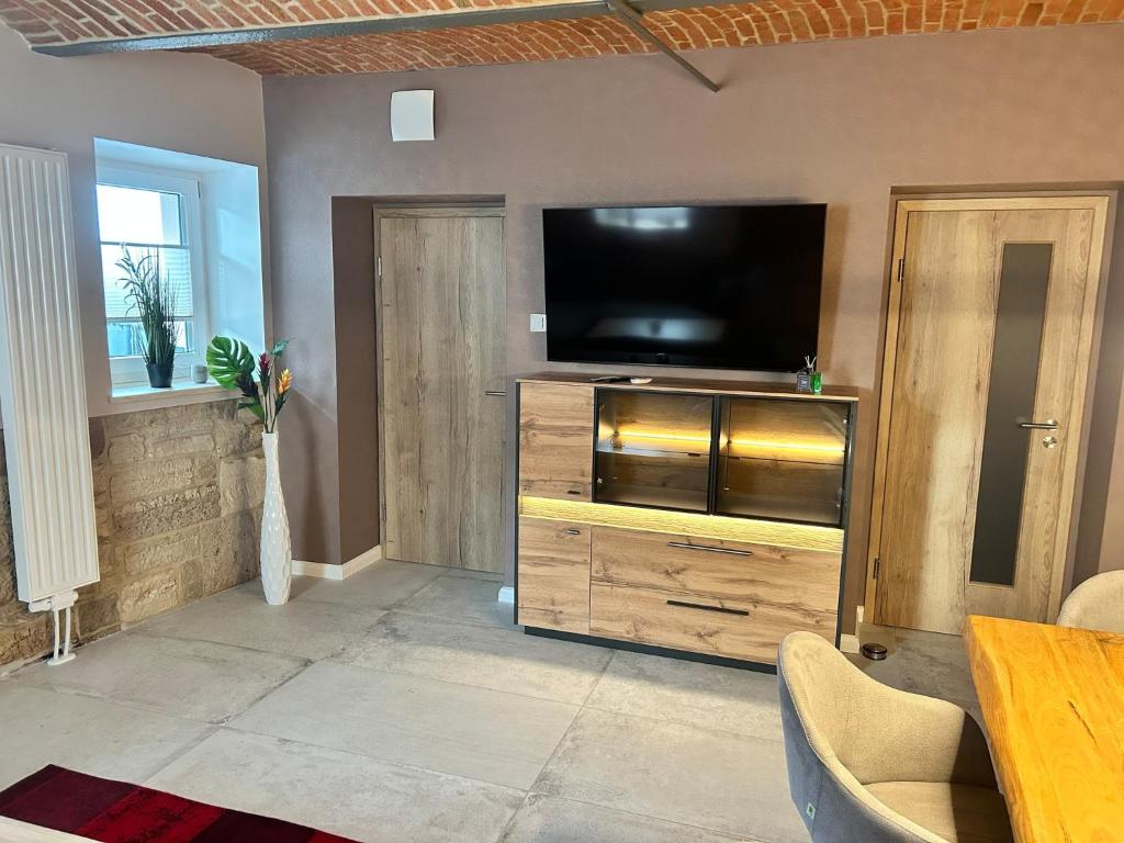 a living room with a flat screen tv on a wooden entertainment center at Chalet Apartment 1 