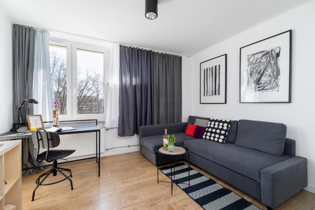 a living room with a couch and a desk at Pet-Friendly Cosy Studio Skarbińskiego by Renters in Krakow