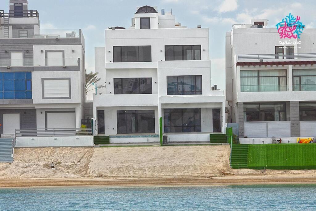 a building on the beach next to the water at Chalet 2200 in Al Khīrān