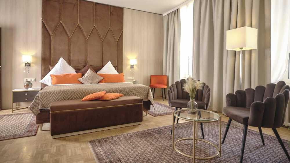 1 dormitorio con cama, sofá y sillas en Hotel van Bebber, en Xanten