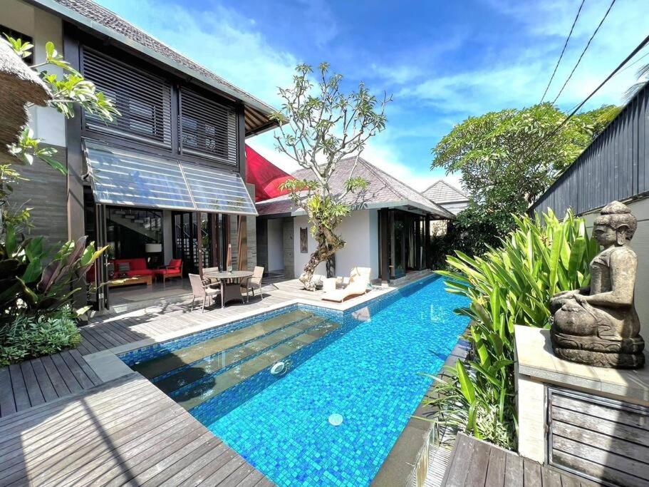 una piscina frente a una casa con jardín en Villa Canthy@Seminyak, en Seminyak