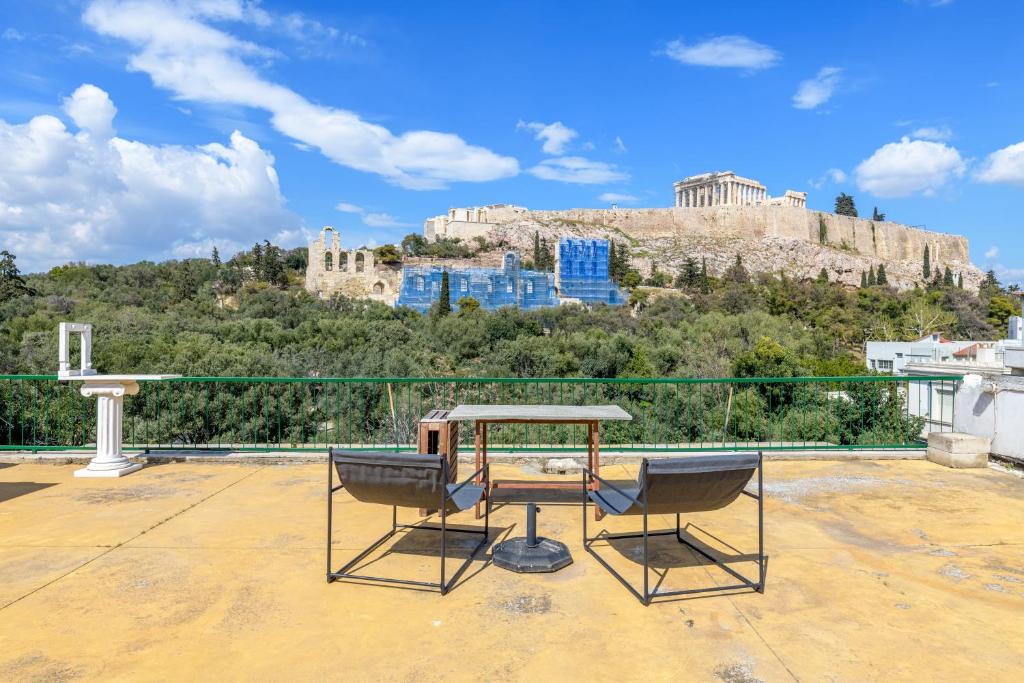 een tafel en stoelen op een dak met uitzicht op kippen bij Holodek Apartments : Parthenon in Athene
