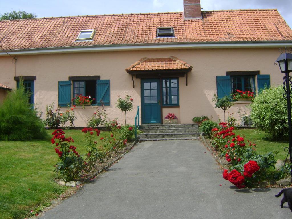 Ponches-EstruvalLes Kiwis的一座带蓝色门和红色鲜花的房子