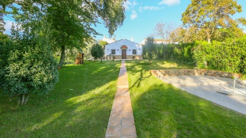 Un jardín con una casa al fondo en Casa Rural “La Julianita”, en Castaño de Robledo