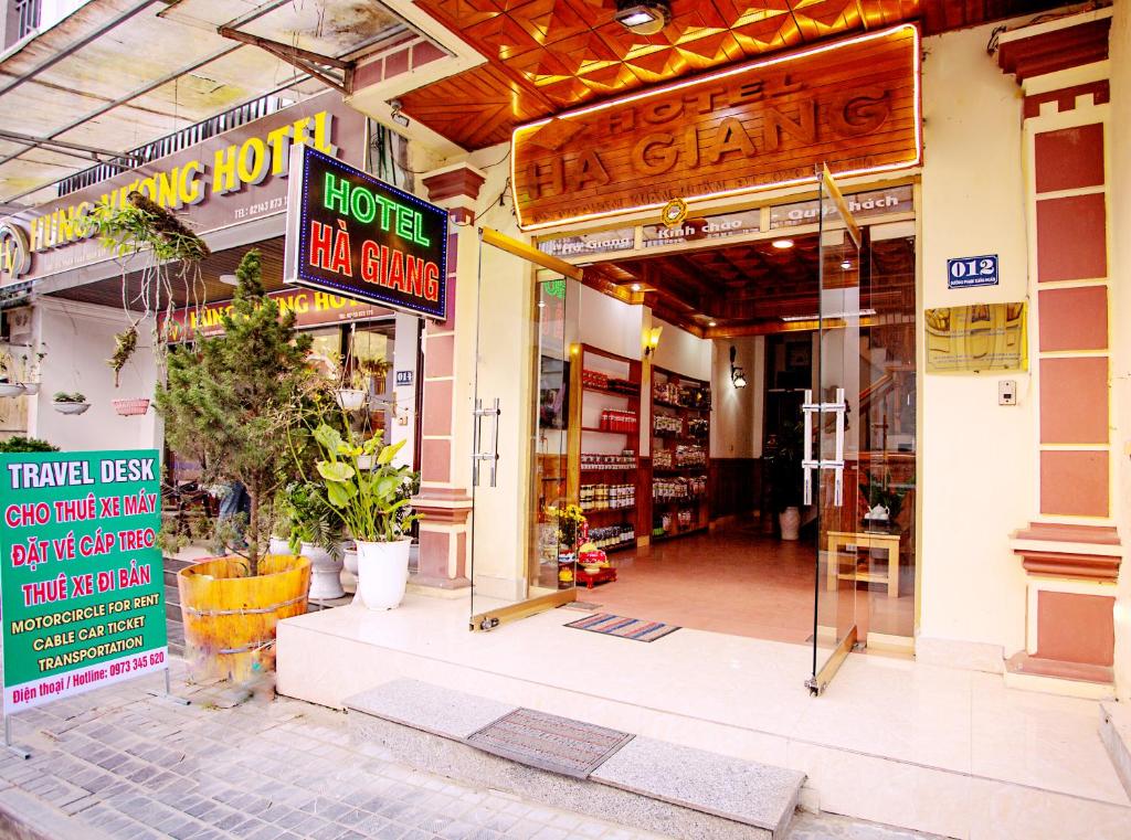 een winkel met borden aan de voorzijde van een gebouw bij Hà Giang Hotel Sapa in Sa Pa