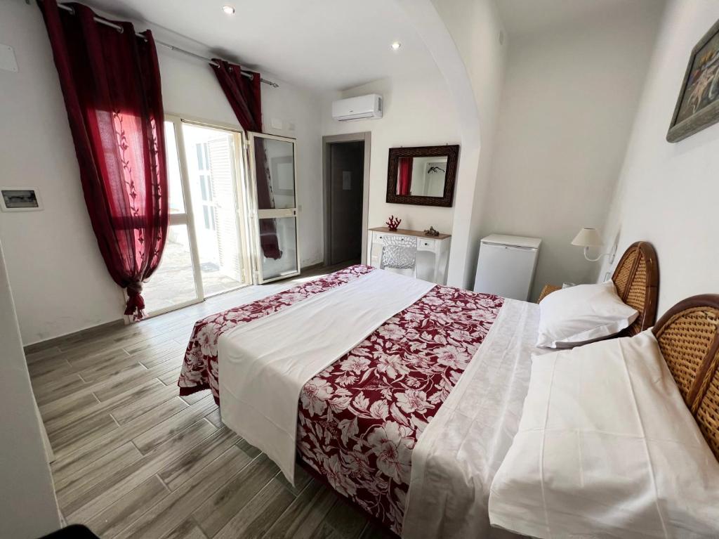 una camera da letto con un grande letto con tende rosse di Camere Dieci Maggio a Ponza