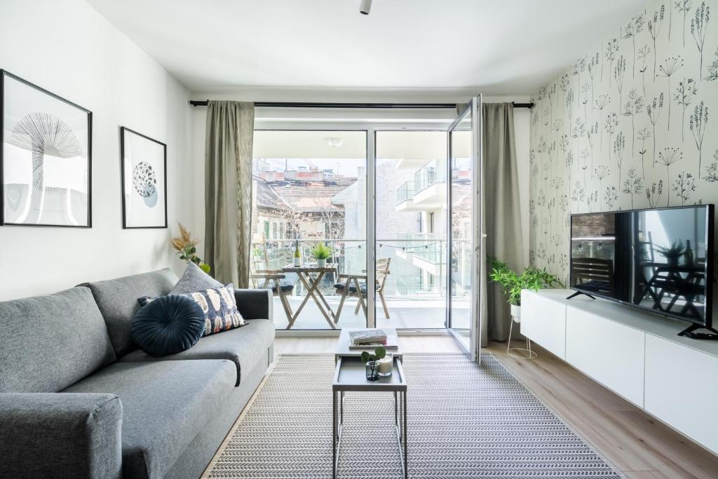 - un salon avec un canapé et une télévision dans l'établissement Cosy Tolnai street Apartments, à Budapest