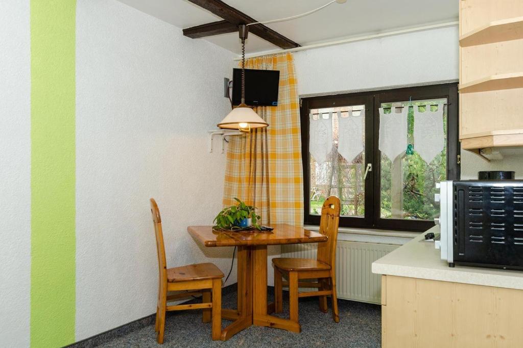 a kitchen with a table and chairs in a kitchen at 2-Personenappartement-in-Schaprode-auf-Ruegen-Zi1 in Schaprode