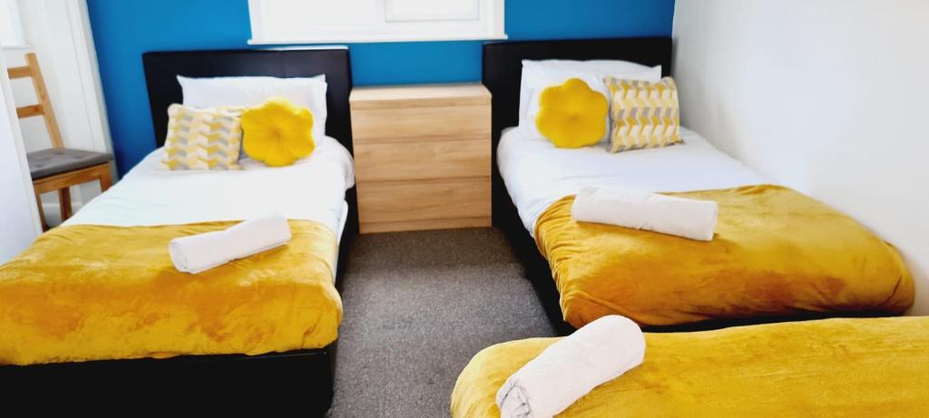 two beds in a room with yellow and white sheets at Browning House Bedrooms I Long or Short Stay I Special Rate Available in Derby