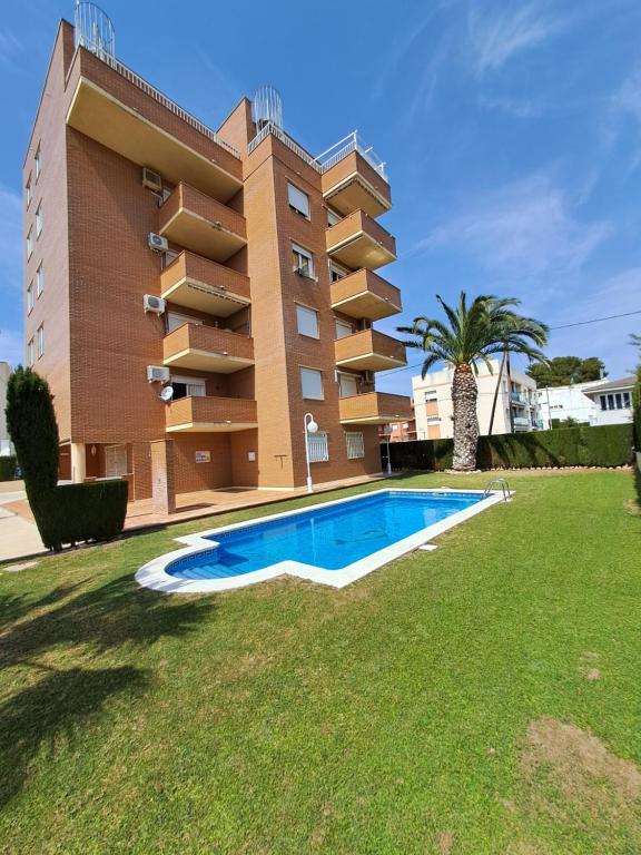 un bâtiment avec une piscine en face d'un bâtiment dans l'établissement Résidence Maëlla, à Miami Platja