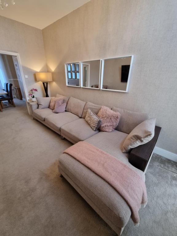 a living room with a couch and a mirror at Lovely home close to MCR centre inc Cinema in Manchester