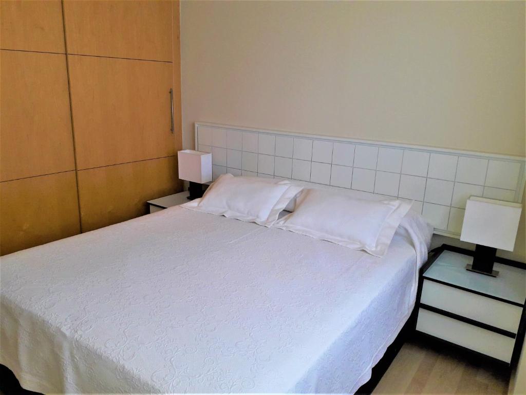 A bed or beds in a room at Atico Pacifico Parking y Piscina gratis