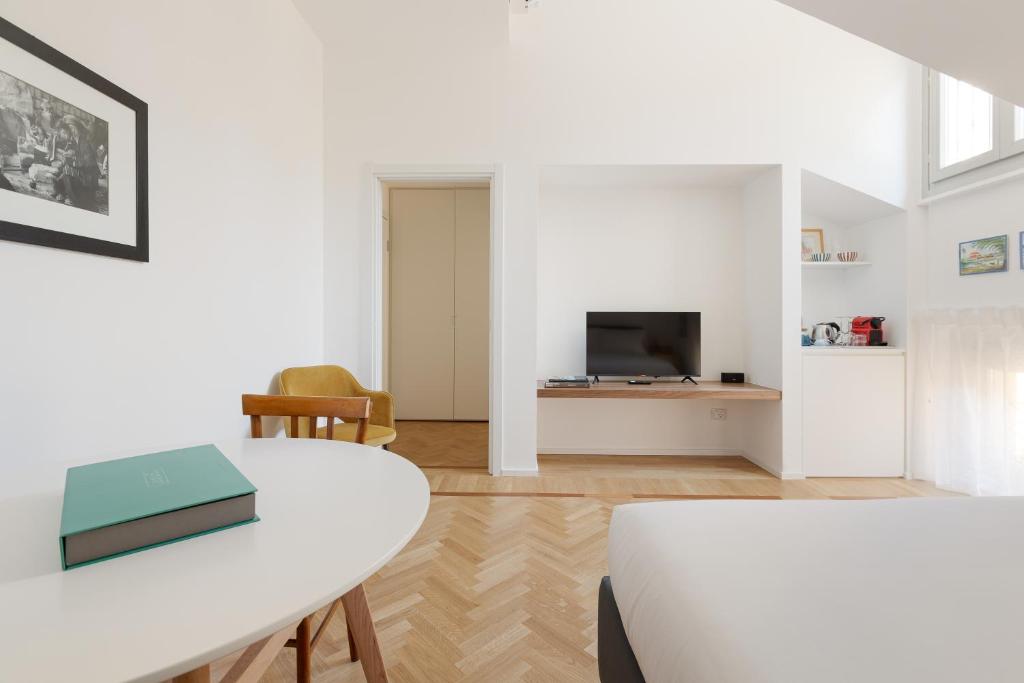 a living room with a white table and a tv at Spiga 46 Suites by Brera Apartments in Milan