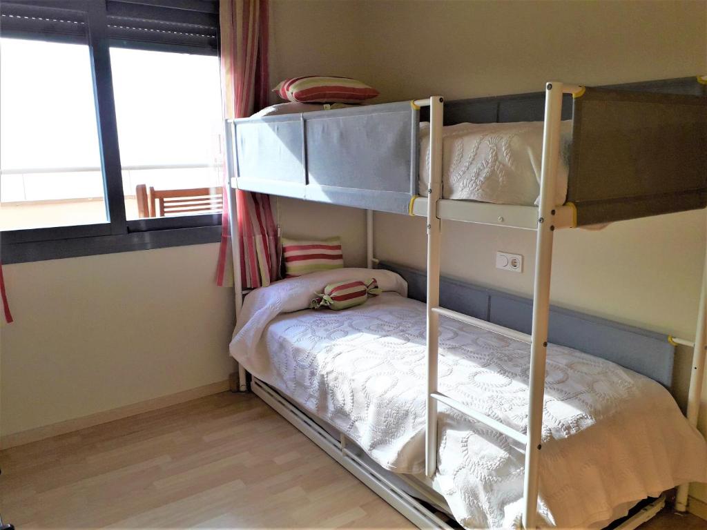 A bed or beds in a room at Atico Pacifico Parking y Piscina gratis
