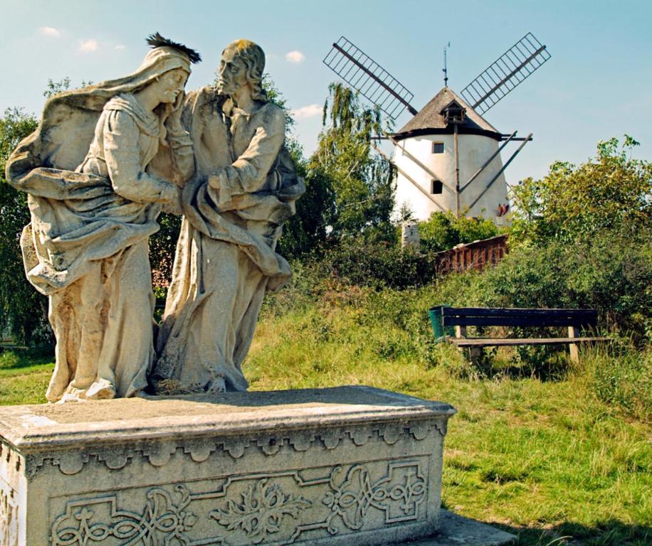 a statue of two women standing next to a windmill at Ferienhaus Scheer in Retz
