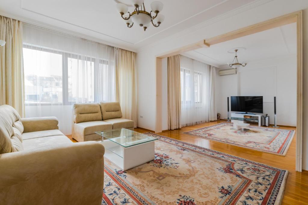 a living room with a couch and a tv at Bright 2-BD Top Central Apartment in Sofia