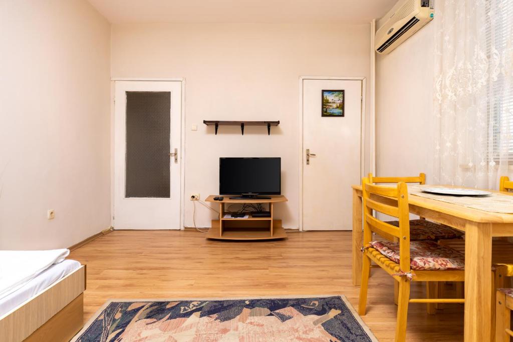 een woonkamer met een tafel en een televisie bij 1-Bedroom Flat with Balcony in Plovdiv in Plovdiv