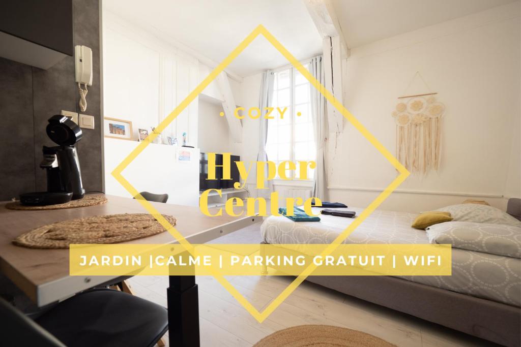 a room with two beds and a table with yellow words inventory centres at La Chouette de la Cathédrale - Calme - Jardin - Wifi in Troyes