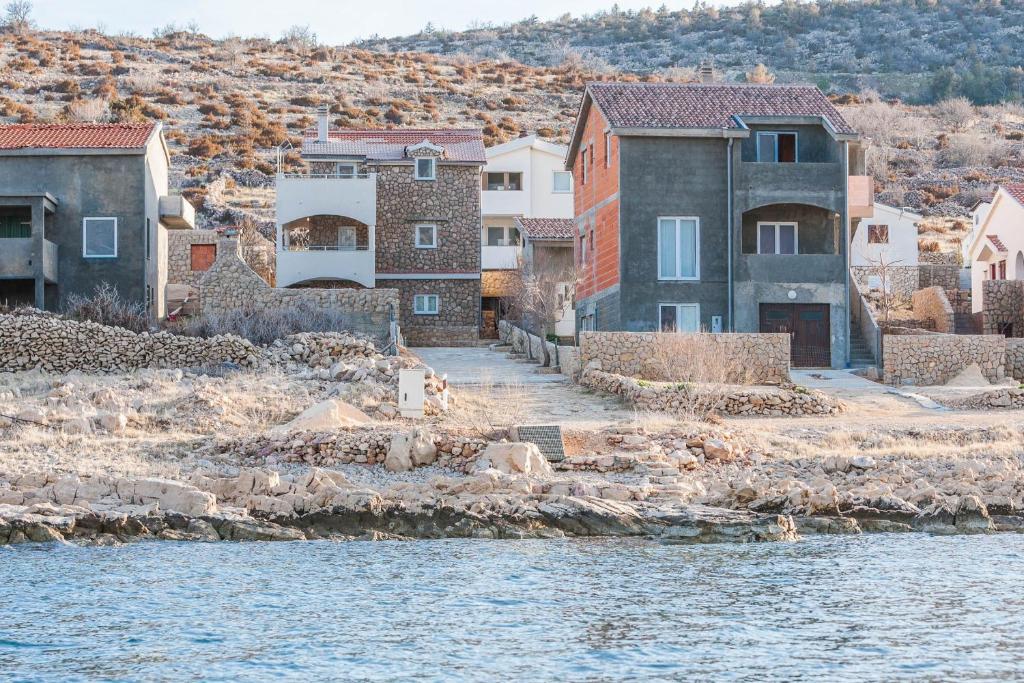 een groep huizen naast het water bij Apartments Karlo in Vinjerac