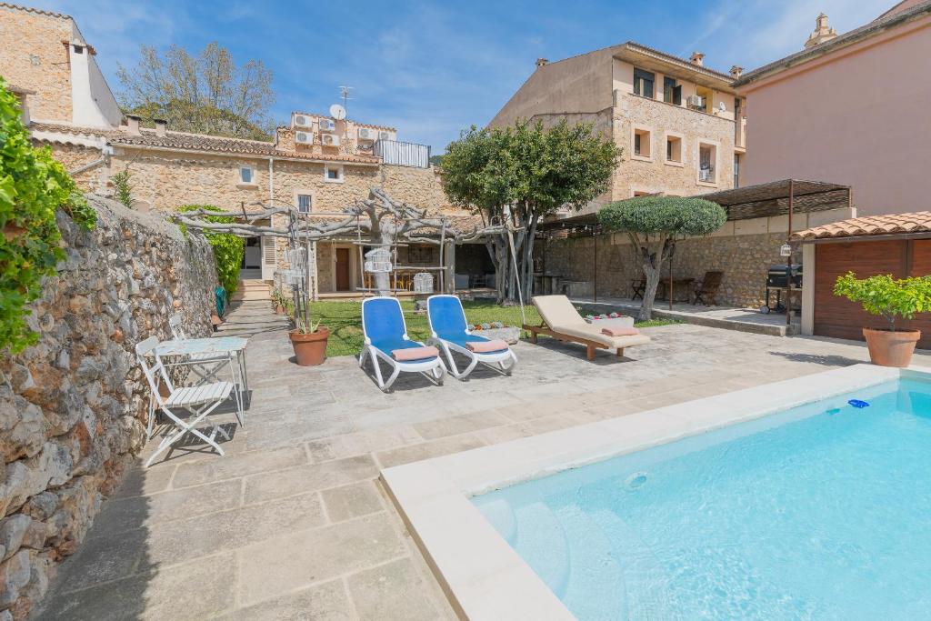 カイマリにあるPintor - Rustic Mallorquin town house 3 bedrooms and pool in Caimariのパティオ(椅子2脚付)、スイミングプールが備わります。