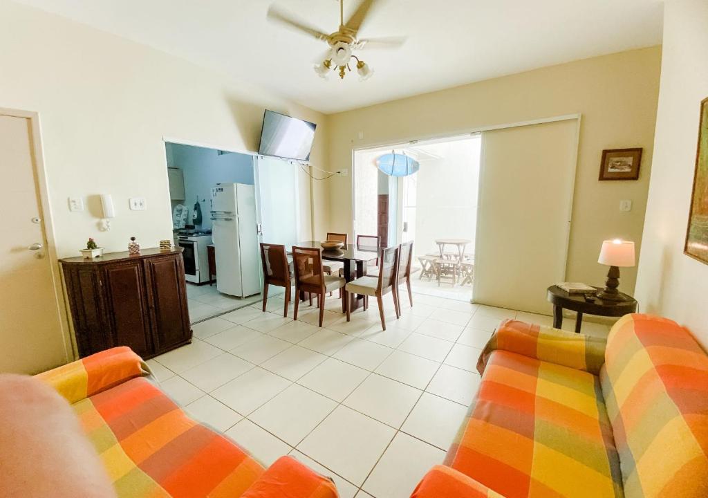 uma sala de estar com um sofá e uma sala de jantar em Terreo 3qtos,6camas,3tvs em Cabo Frio