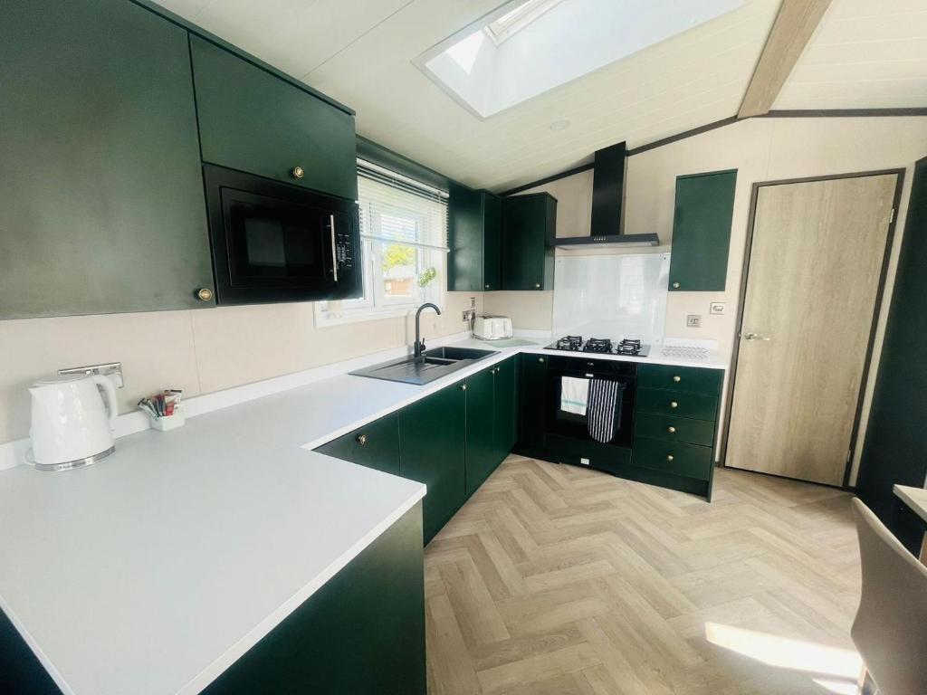 a kitchen with green cabinets and a white counter top at Evergreen Lodge with Hot Tub in York