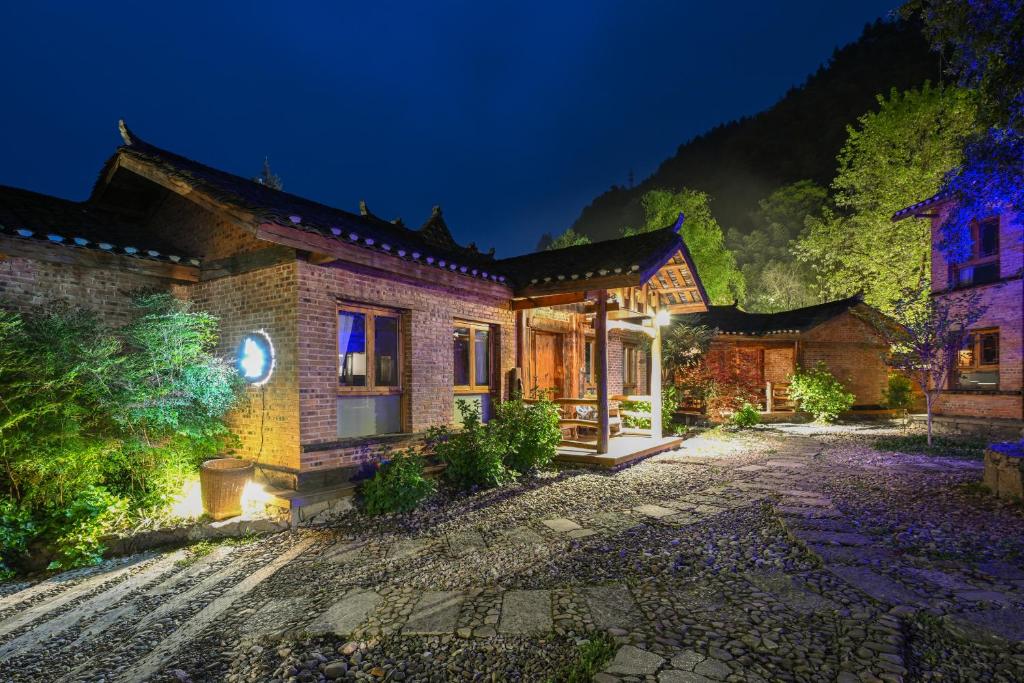 una casa con un patio iluminado por la noche en No.5 Valley Lodge en Zhangjiajie