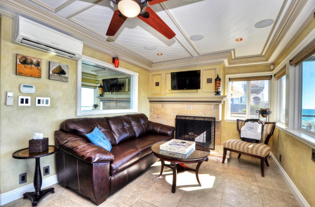 a leather couch in a living room with a fireplace at Villa Bella Mare at the Retreat in Laguna Beach in Laguna Beach