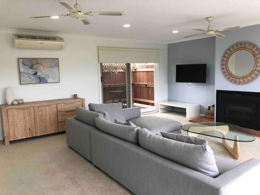 a living room with a couch and a tv at 4 bedroom family holiday home with large deck in Blairgowrie