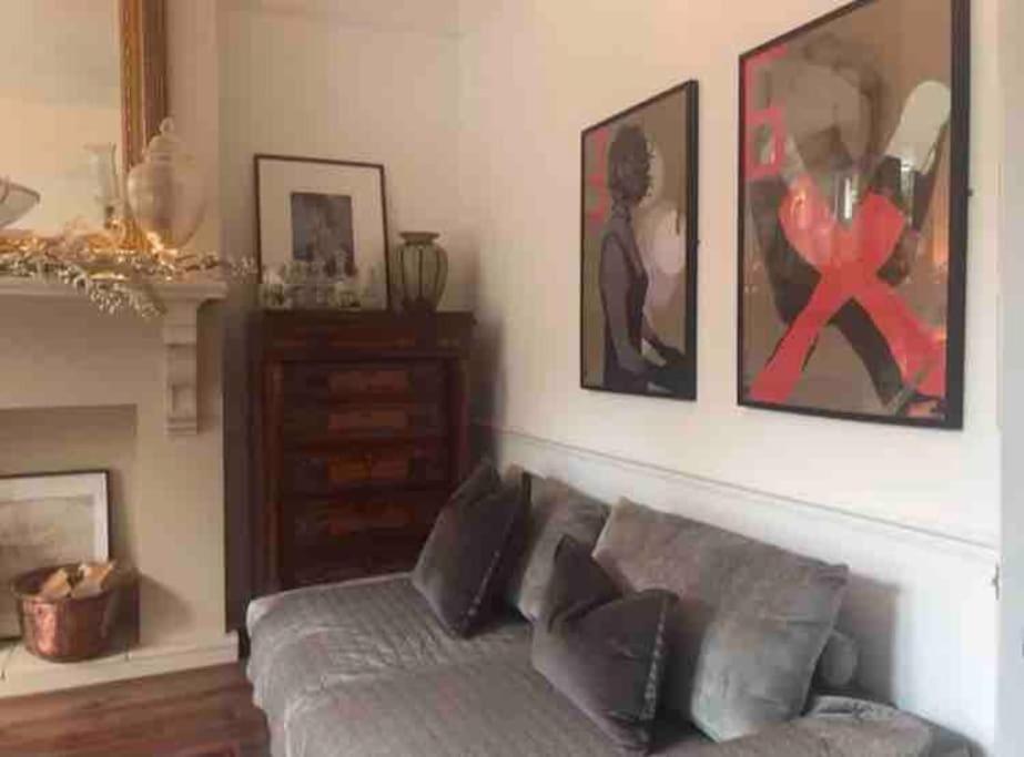 a living room with a couch and paintings on the wall at Lakeside View Arts and Craft Apartment in Liverpool