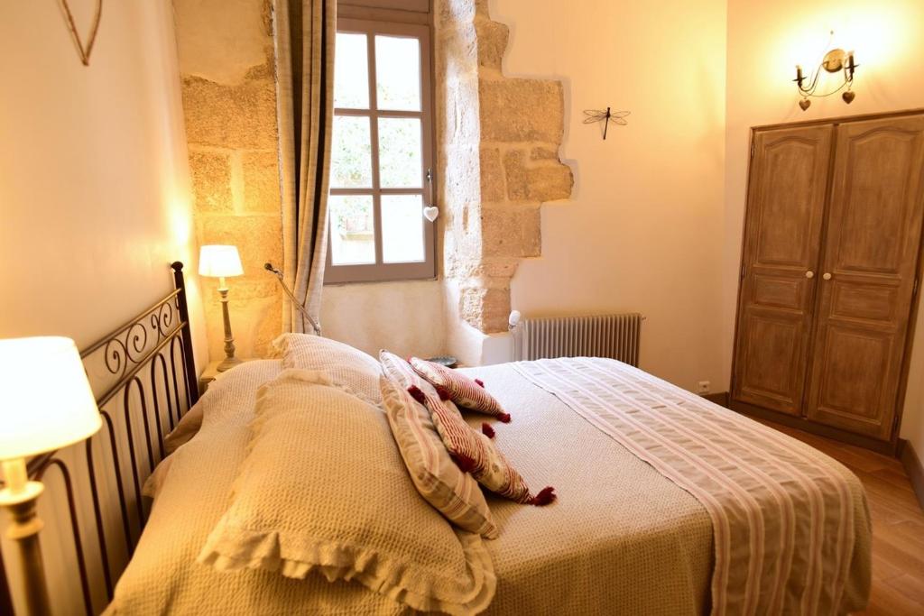 une chambre avec un lit avec une couverture et une fenêtre dans l'établissement Walnut, à Sarlat-la-Canéda