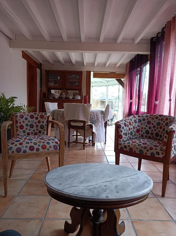 un soggiorno con sedie e tavolo di Maison de tout vent a Pierrefonds
