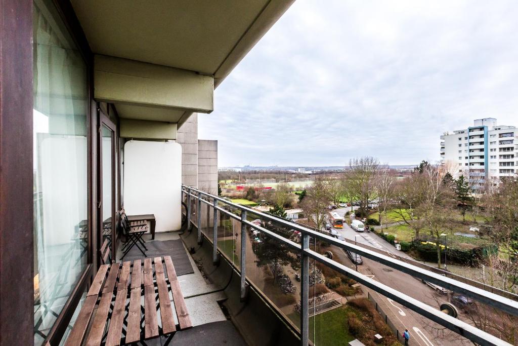 a balcony with a wooden bench on a building at Ferienwohnung Köln Junkersdorf in Cologne