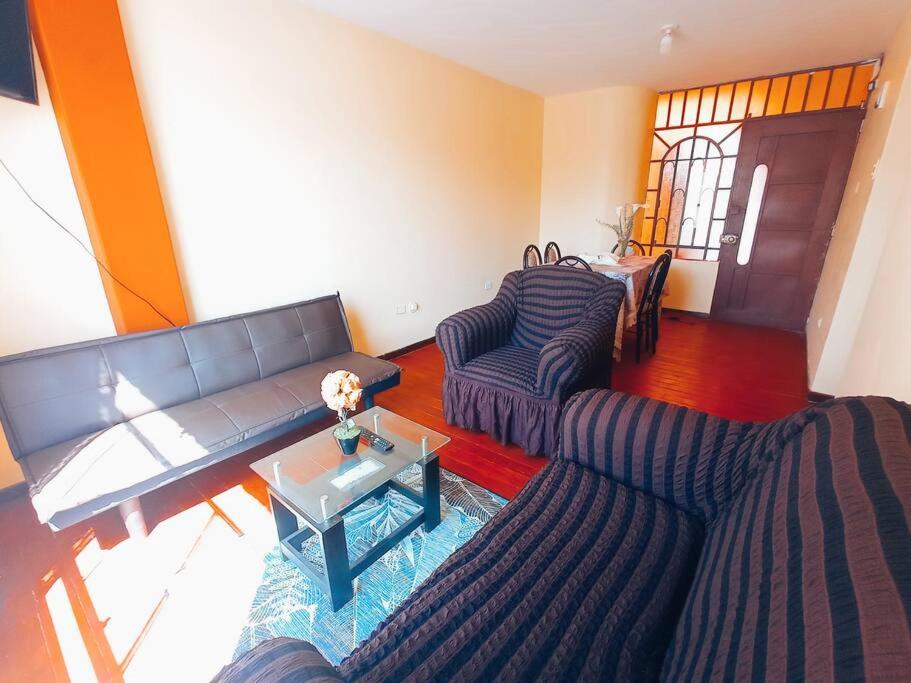 a living room with two couches and a table at Departamento cerca al centro de Huancayo. in Huancayo