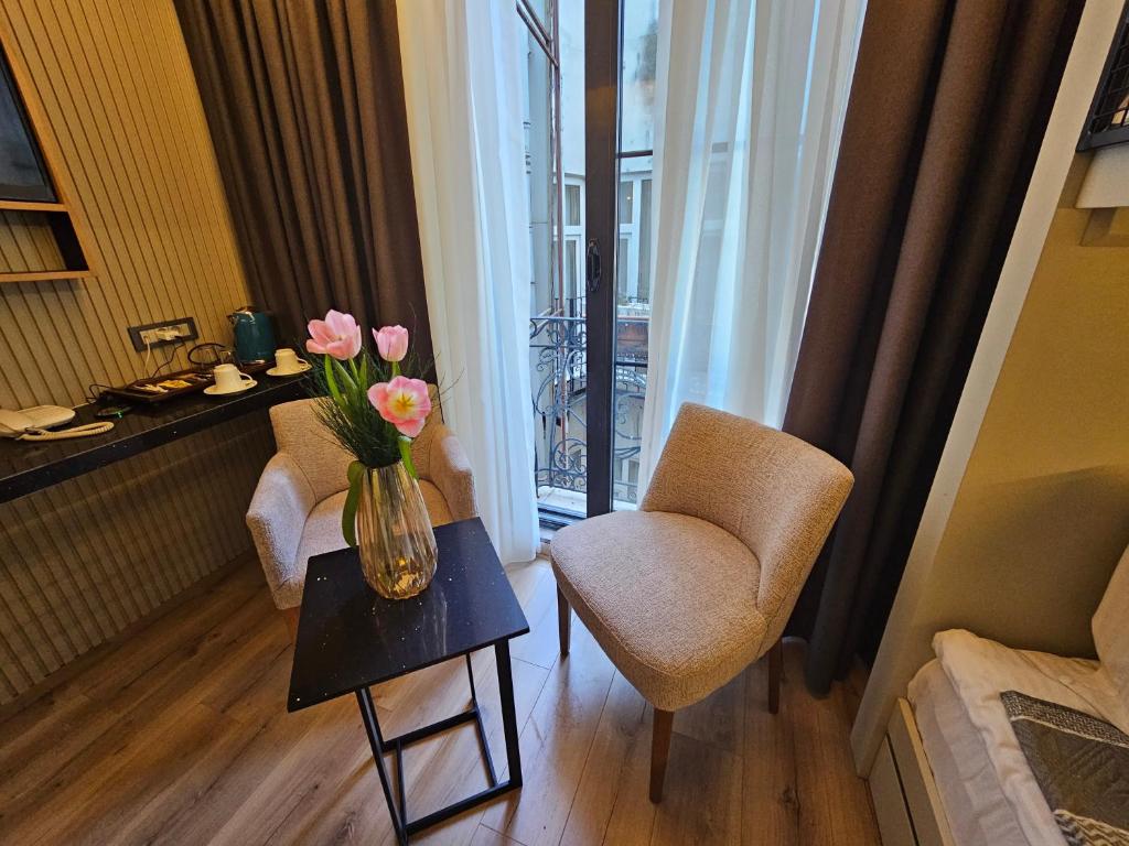 a room with two chairs and a vase of flowers on a table at Anthemis Hotel in Istanbul
