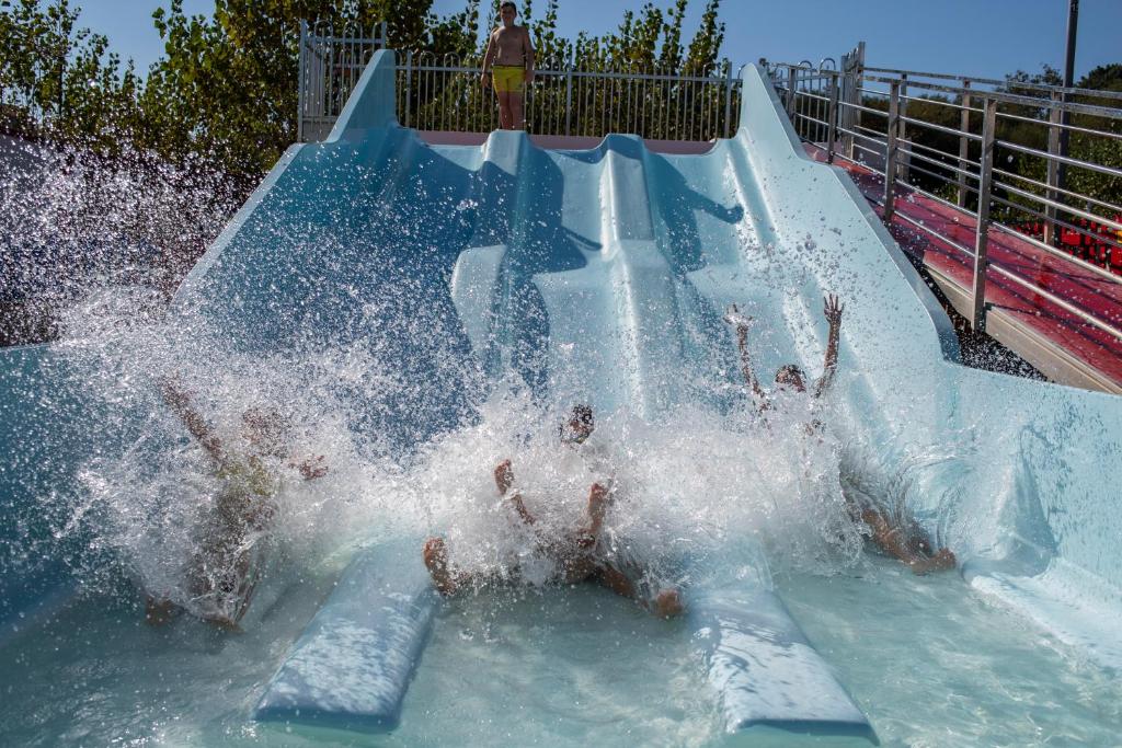a group of children playing on a water slide at Camping Baltar in Portonovo
