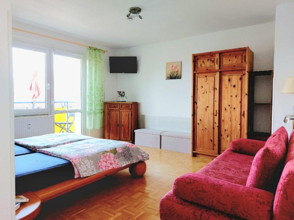 1 dormitorio con cama, sofá y ventana en Helles Apartment mit Balkon am Großen Garten nahe Stadtzentrum en Dresden