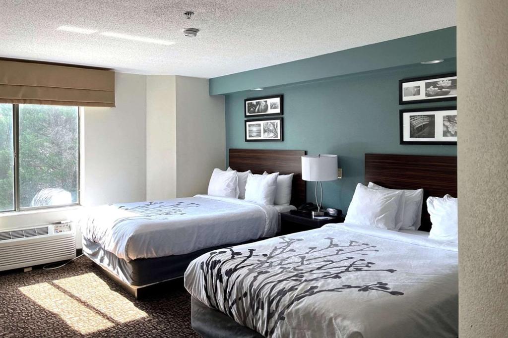 Habitación de hotel con 2 camas y ventana en Caper House Inn, en Augusta